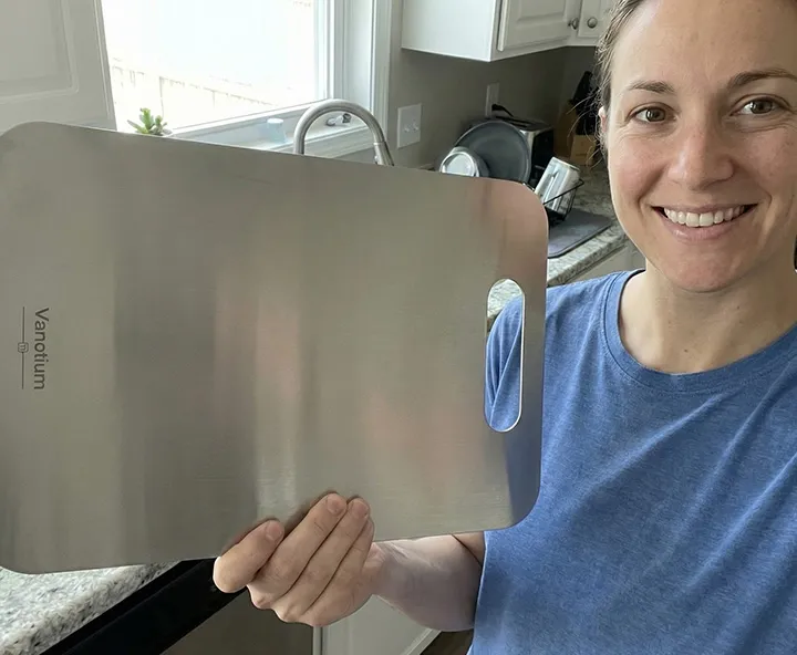 Woman holding the Vanotium cutting board in the kitchen